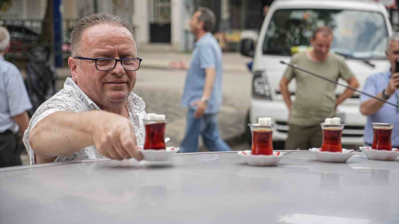 50 metre uzaklıktaki çay ocağından aldığı çayları otomobiliyle taşıyor