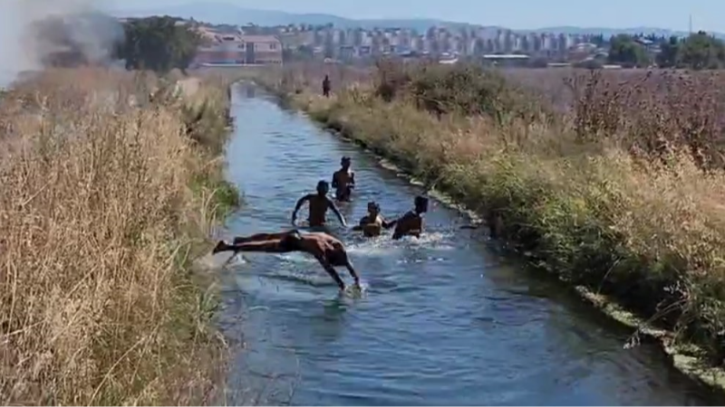 Yangına rağmen su kanalında oynamaya devam ederek çifte tehlikeye davetiye çıkardılar